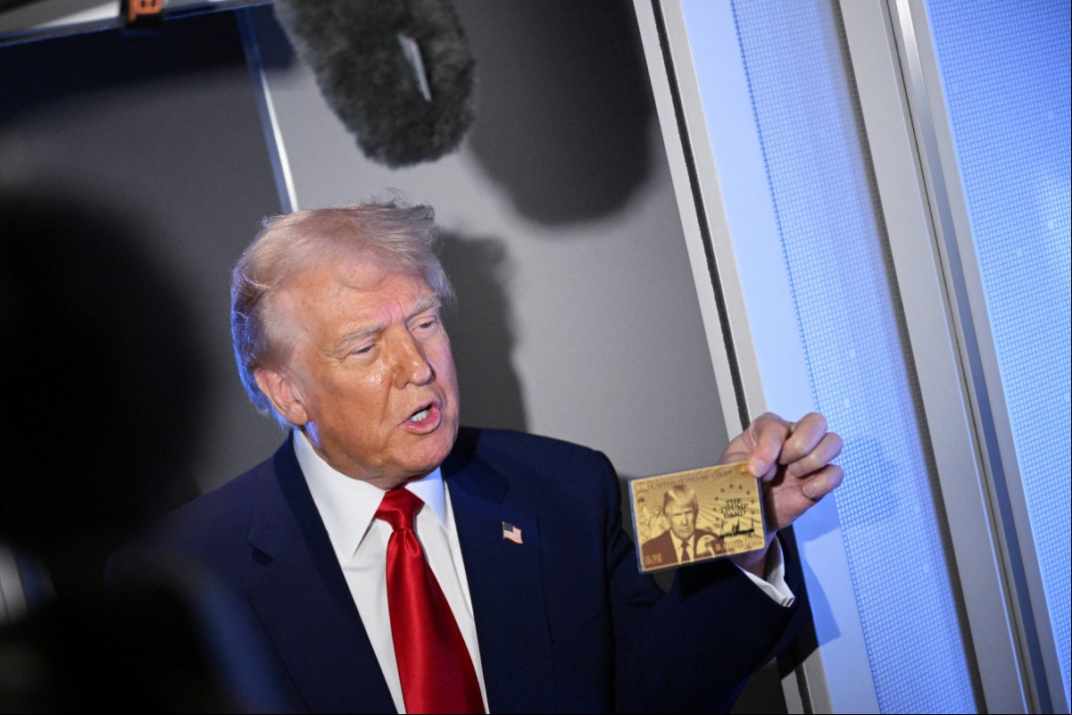 O presidente dos EUA, Donald Trump, segura o Gold Card de US$ 5 milhões enquanto fala com repórteres durante um voo a bordo do Air Force One, a caminho de Miami, Flórida, em 3 de abril de 2025. O presidente Donald Trump divulgou um novo site para sua autorização de residência americana de US$ 5 milhões, planejada para 11 de junho, informando que a lista de espera para o visto dourado foi aberta no TrumpCard.gov. (Foto de MANDEL NGAN / AFP)